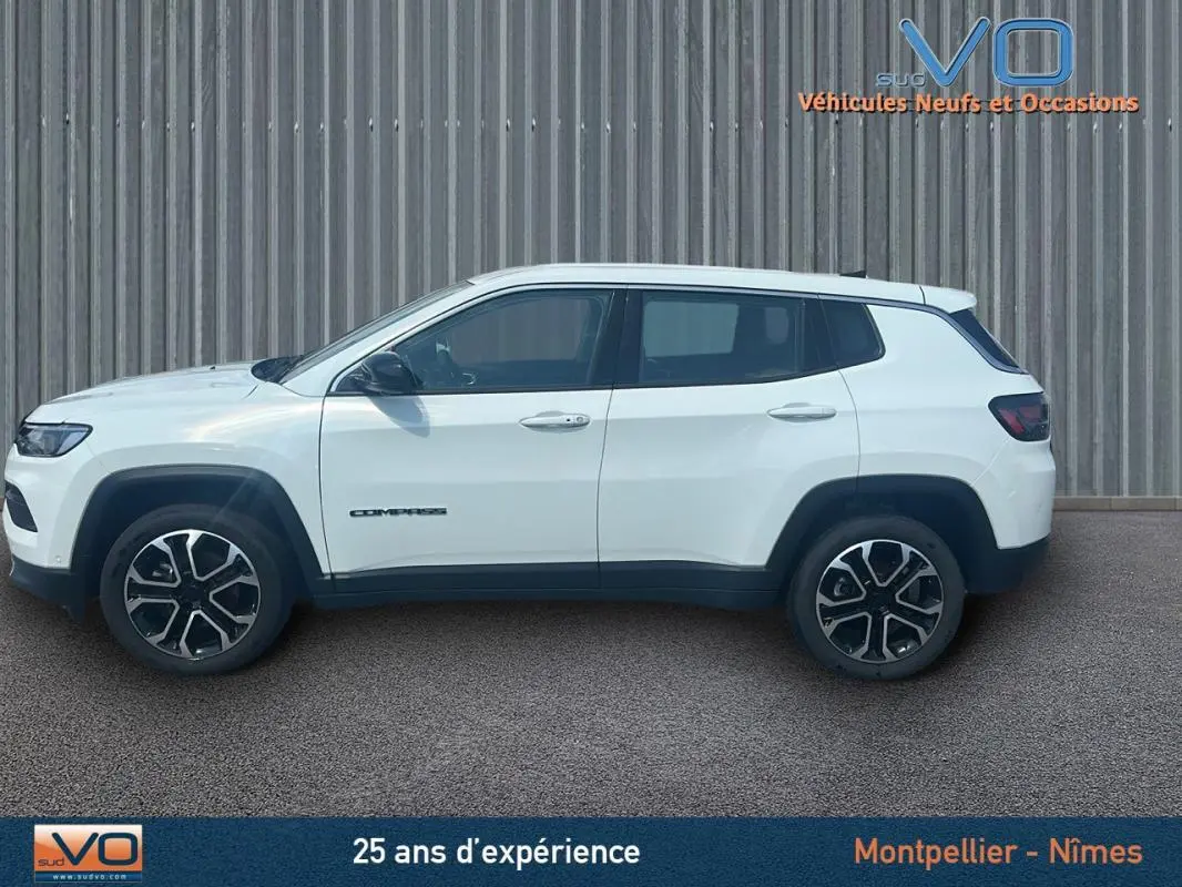 Vue latérale droite du Jeep Compass blanc 2024 avec jantes 17 pouces et roue de secours visible sur fond industriel.