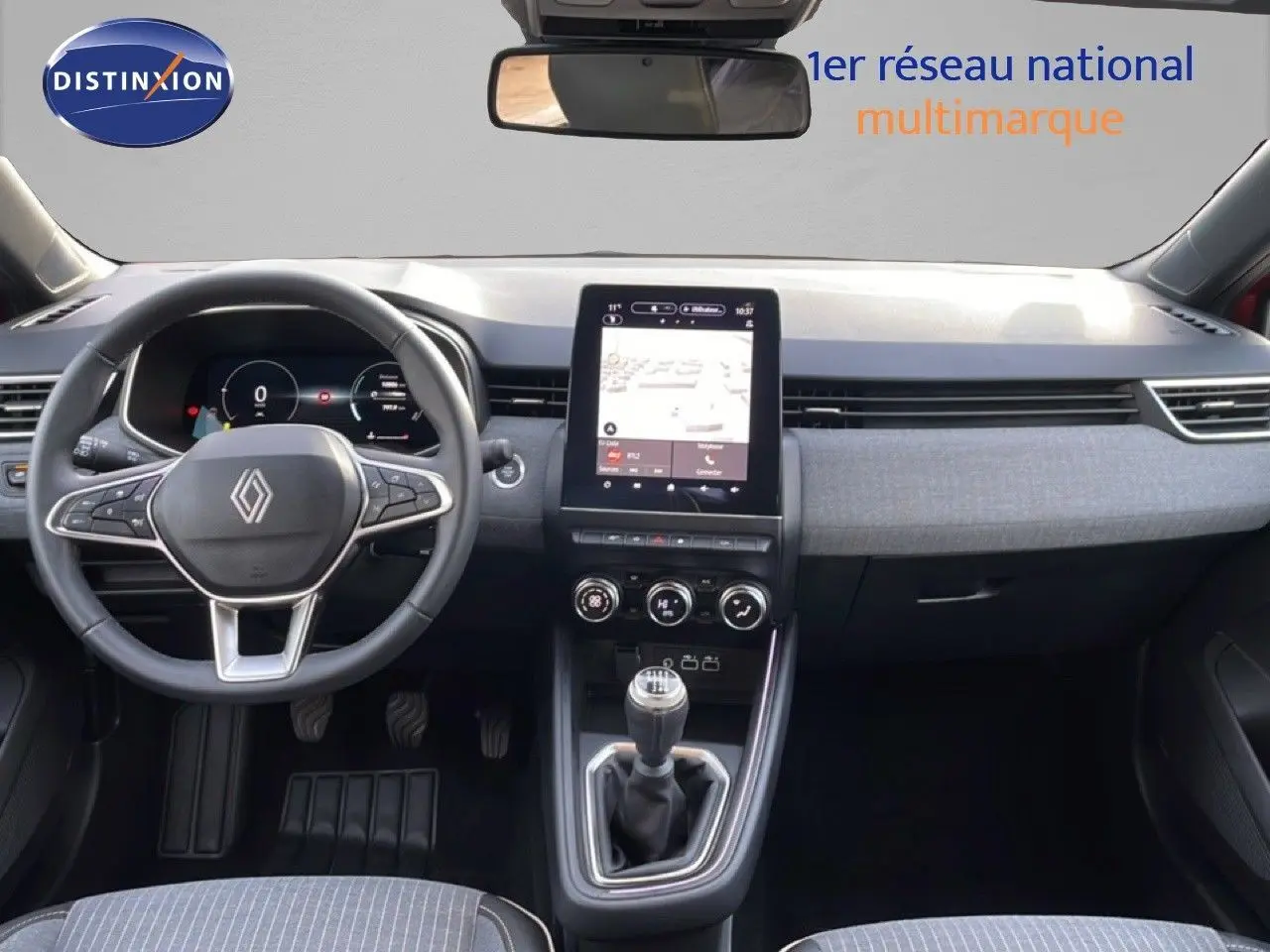 Vue intérieure avant de la Renault Clio rouge Désir Métal 2025, avec tableau de bord numérique et boîte manuelle.