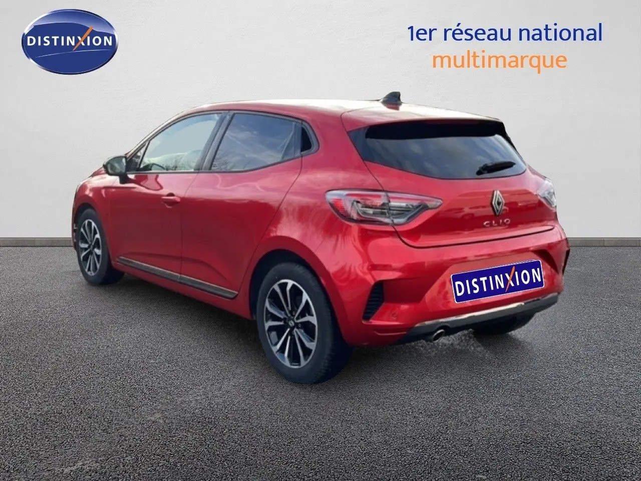 Vue 3/4 arrière droite d'une Renault Clio rouge désir métal 2025 avec jantes alliage et vitres teintées.