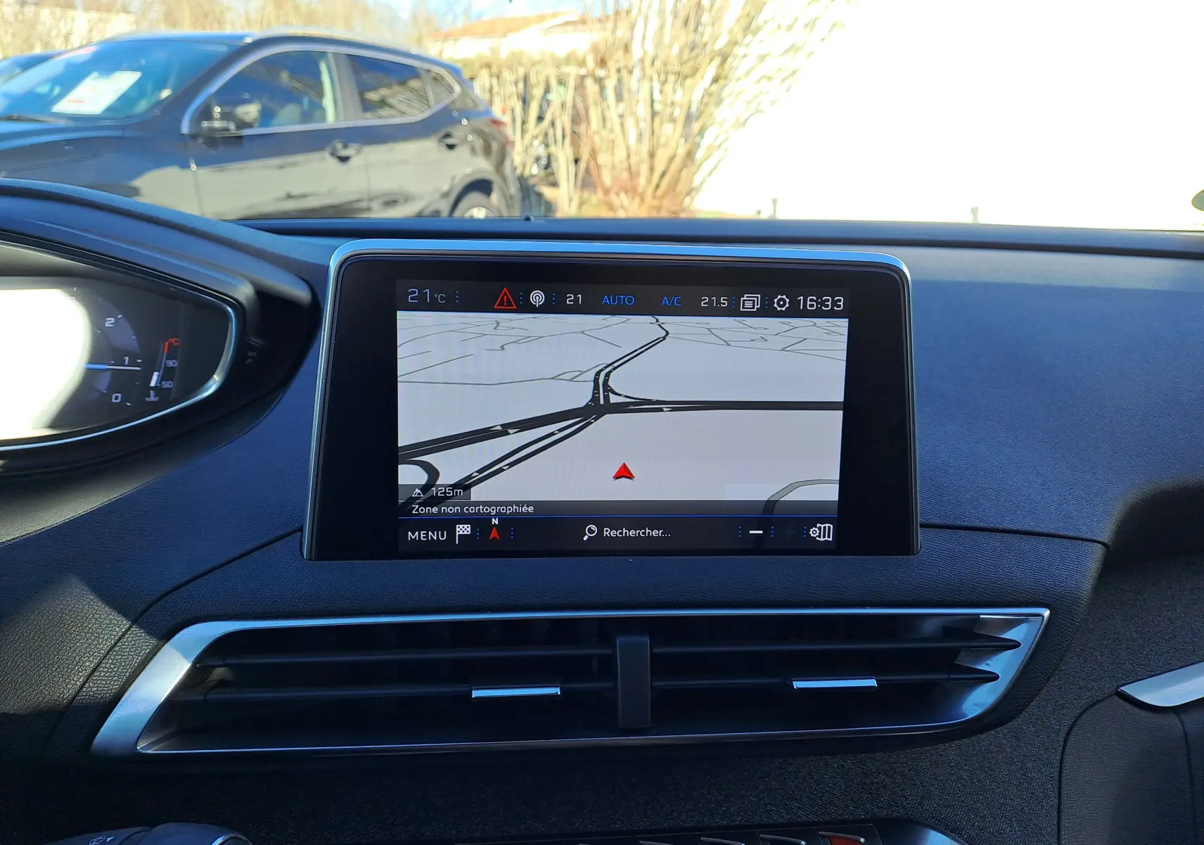 Vue intérieure centrée sur l'écran tactile du tableau de bord du Peugeot 5008 gris, affichant la navigation GPS.
