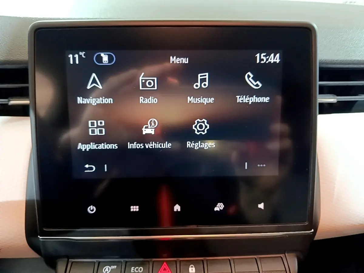Écran tactile central de la Renault Clio Business blanc, affichant le menu principal avec options multimédia et navigation.