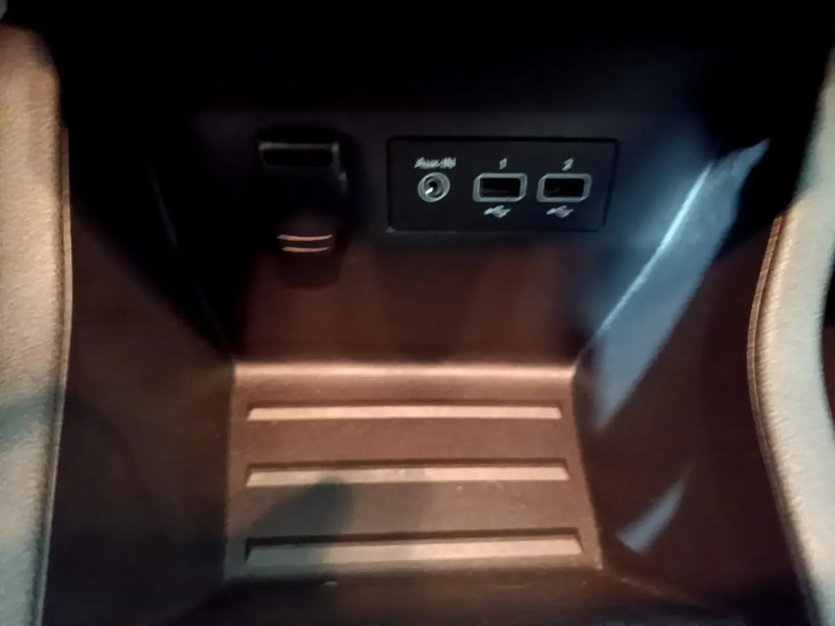 Vue rapprochée de la console centrale noire de la Renault Clio Business avec ports USB et prise auxiliaire visibles.
