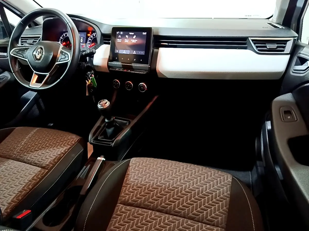 Intérieur Renault Clio Business TCe 100 GPL 2023, vue avant côté conducteur, tableau de bord noir et blanc, sièges marron.