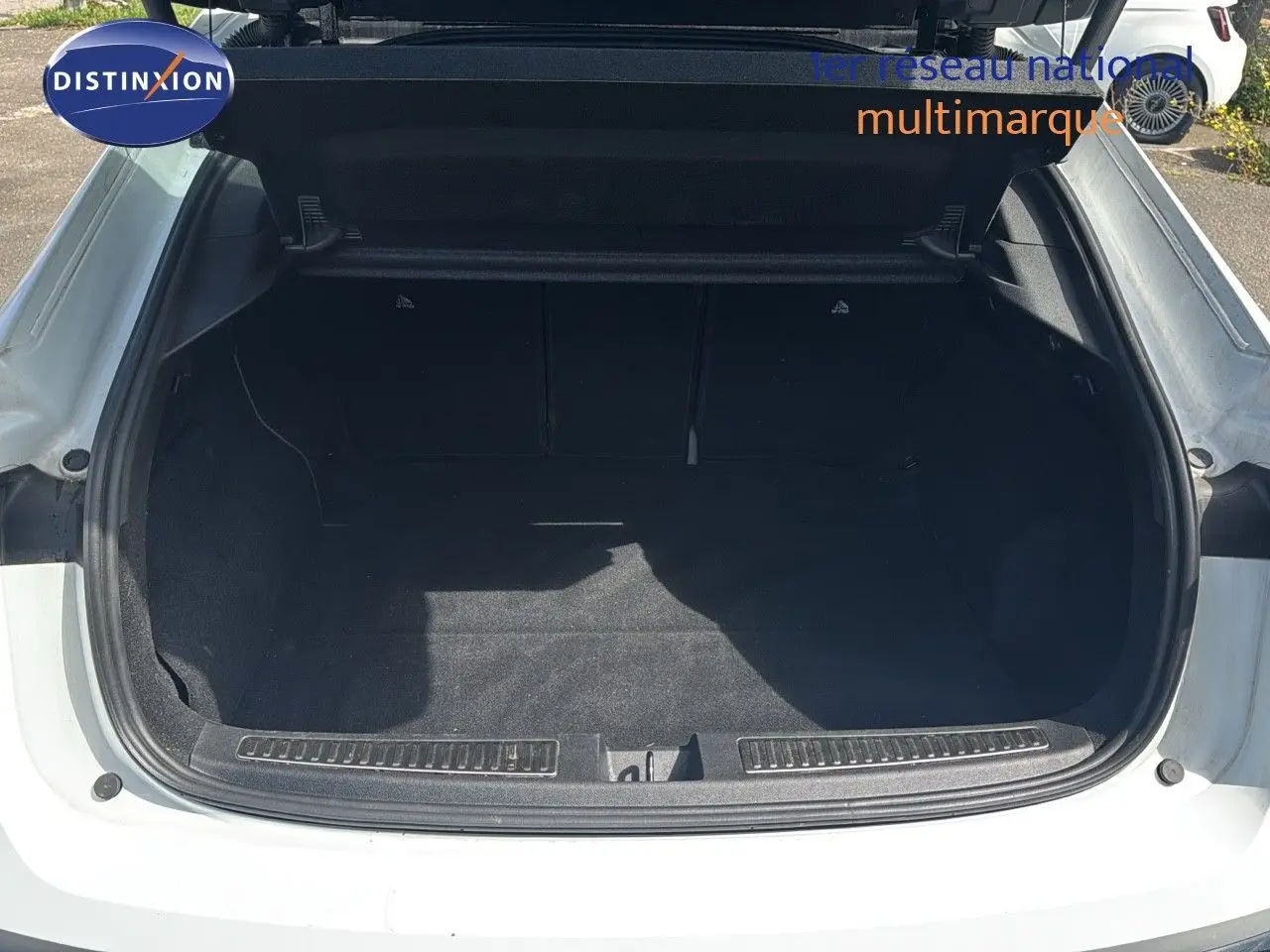 Coffre ouvert vu de l'arrière d'une Renault Rafale blanc satin avec intérieur noir, sans chargement visible.