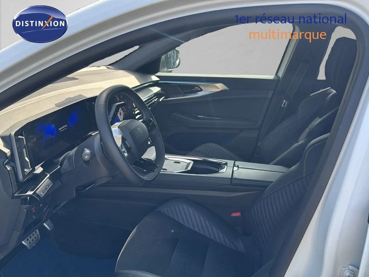 Vue intérieure côté conducteur de la Renault Rafale 2024 blanc satin, volant multifonction et sièges noirs cuir et tissu.