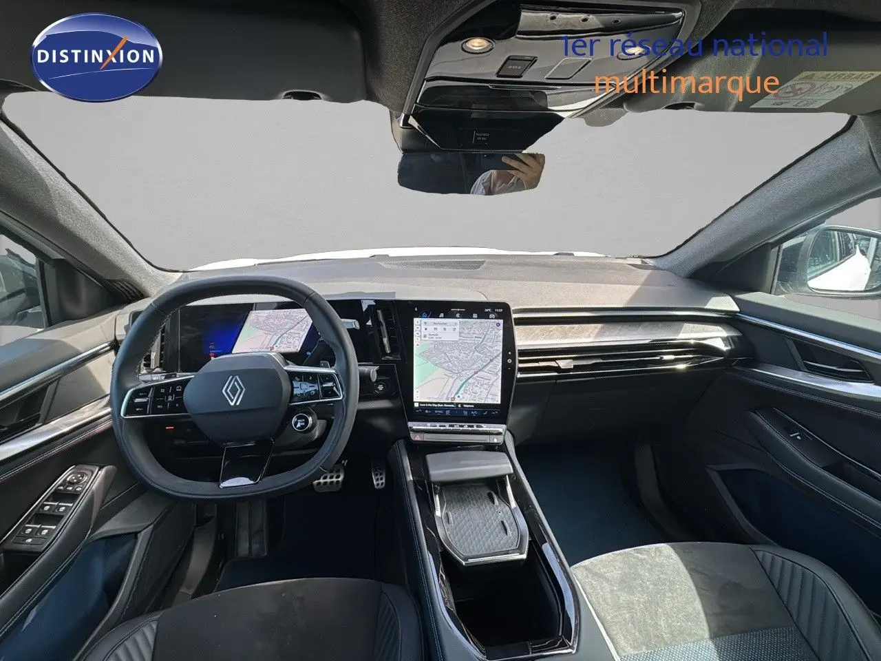 Vue intérieure avant de la Renault Rafale 2024, tableau de bord moderne avec écran tactile central et volant multifonction noir.