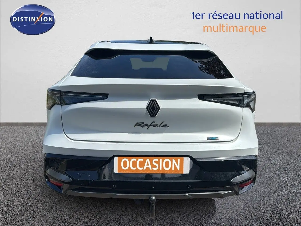 Vue arrière d'une Renault Rafale blanche satin avec toit noir, badge hybride et attelage visible.