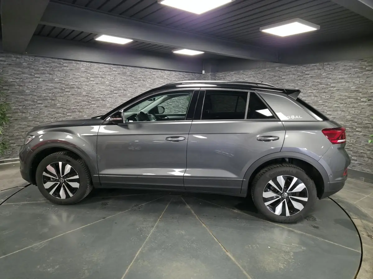 Volkswagen T-Roc gris en profil droit, avec jantes alliage 17 pouces et sticker édition GOAL sur custode arrière.