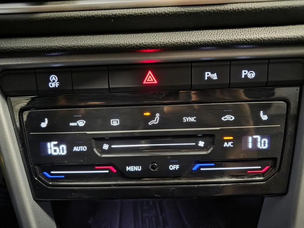 Panneau de commande de la climatisation bi-zone du Volkswagen T-Roc 2025, avec affichage digital et boutons tactiles.