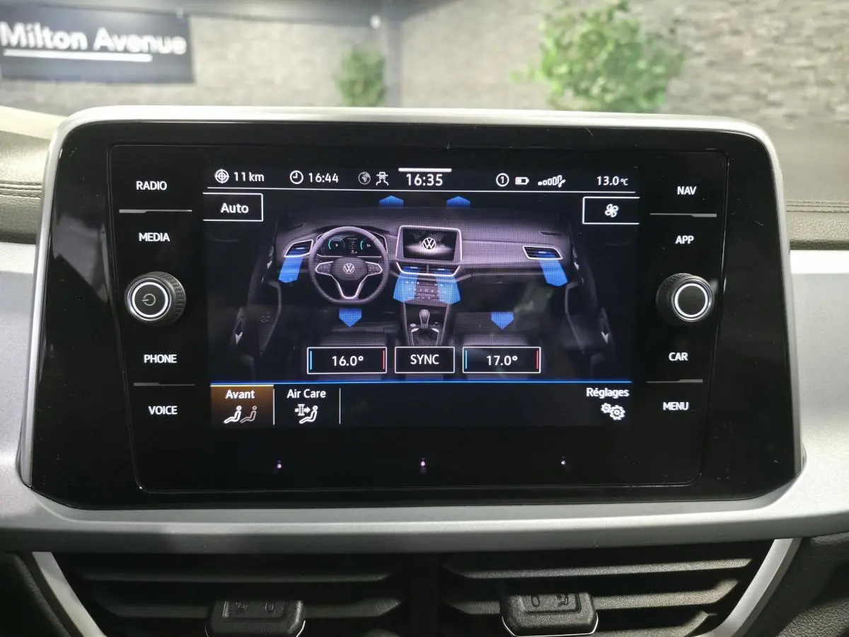 Écran tactile central du Volkswagen T-Roc 2025 affichant les réglages de climatisation bi-zone et la ventilation.