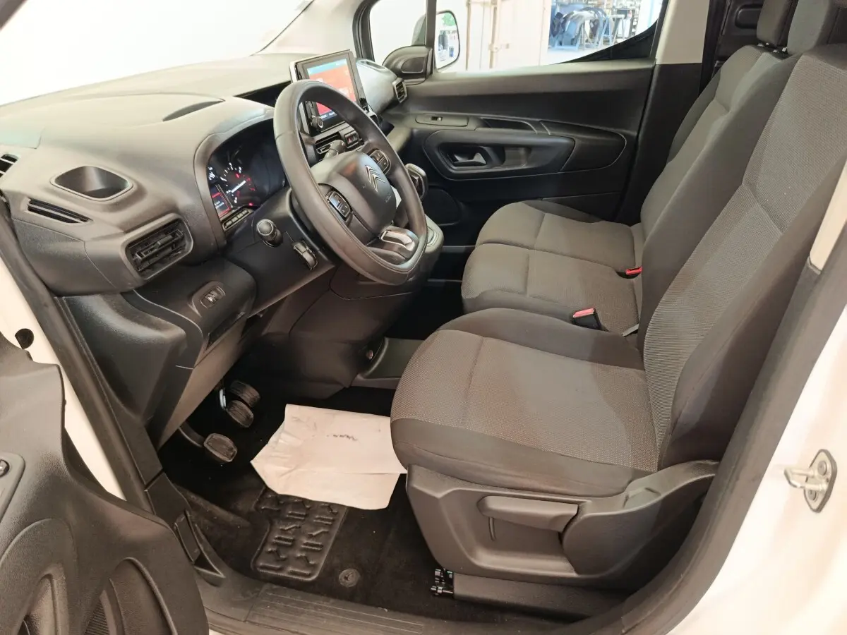 Vue intérieure côté conducteur du Citroën Berlingo blanc 2020, avec tableau de bord et sièges gris visibles.