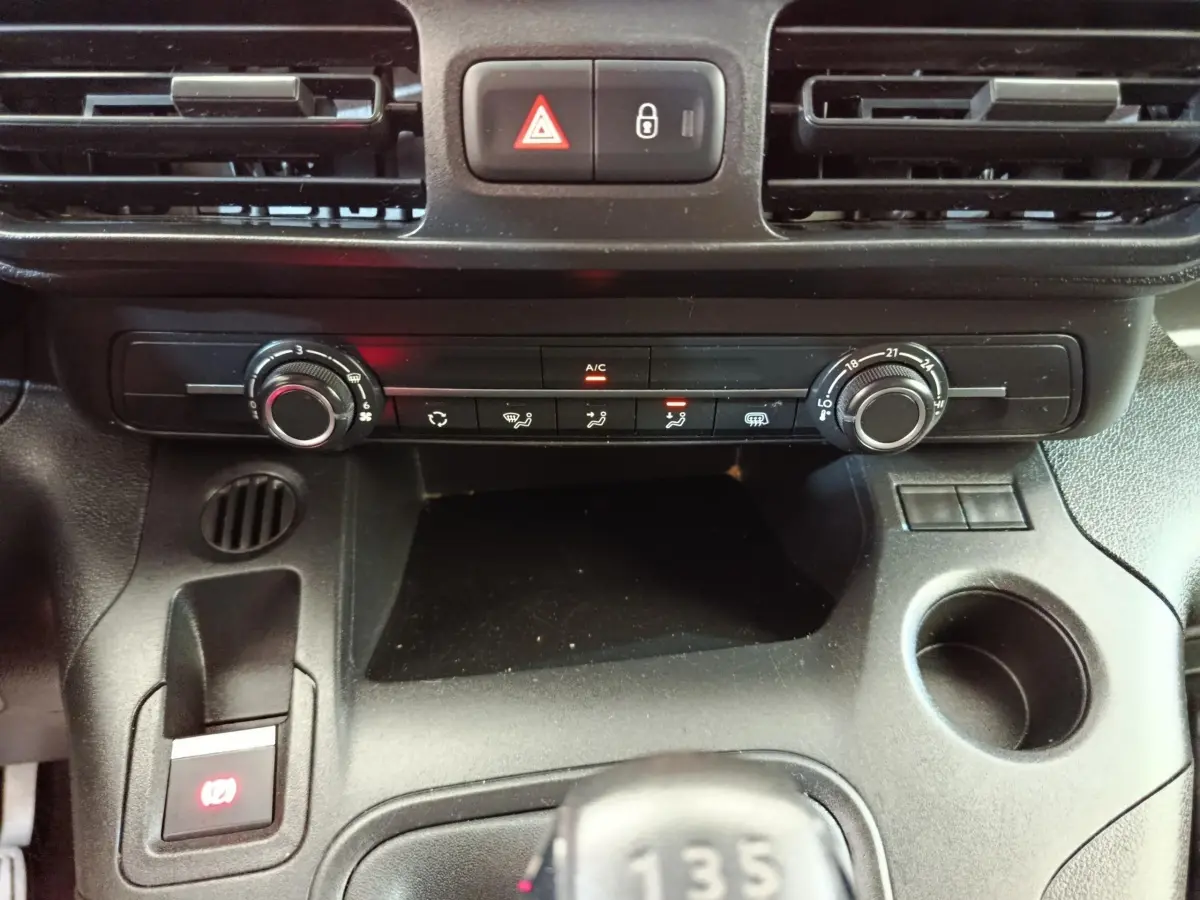 Vue rapprochée de la console centrale noire du Citroën Berlingo 2020, avec commandes climatisation et levier de vitesses manuel.