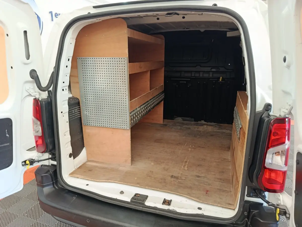 Vue arrière ouverte du Citroën Berlingo blanc 2020 avec aménagements bois intégrés dans l'espace de chargement.