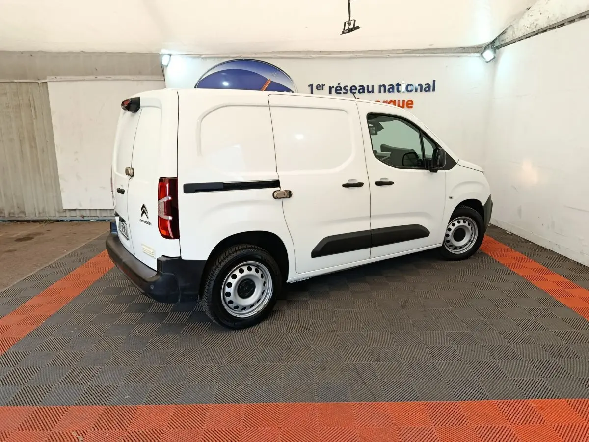 Vue 3/4 arrière droite d’un utilitaire Citroën Berlingo blanc avec porte latérale coulissante et jantes acier.