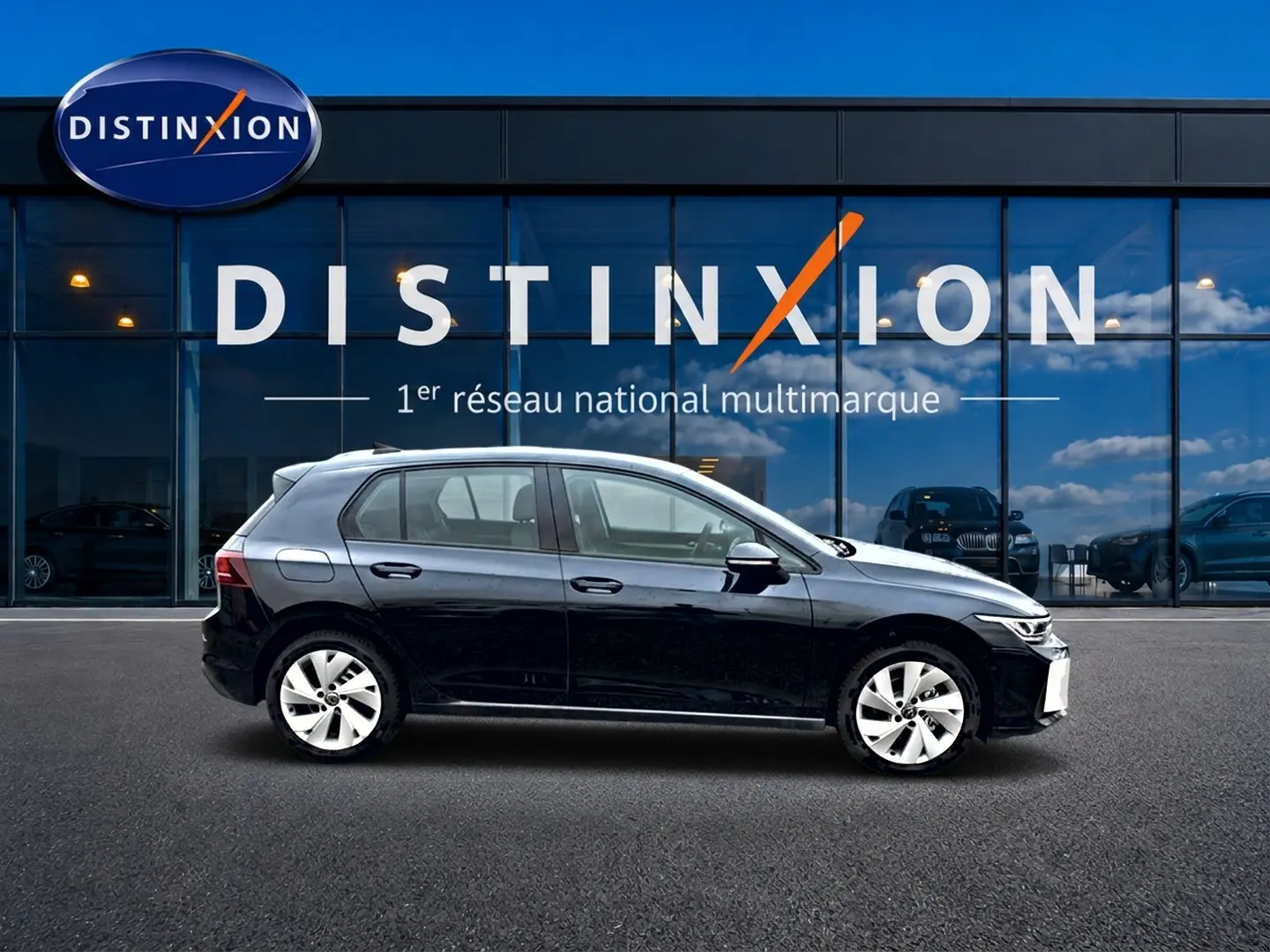 Profil côté gauche d'une Volkswagen Golf noire 2026 garée devant une vitrine avec logo Distinxion.