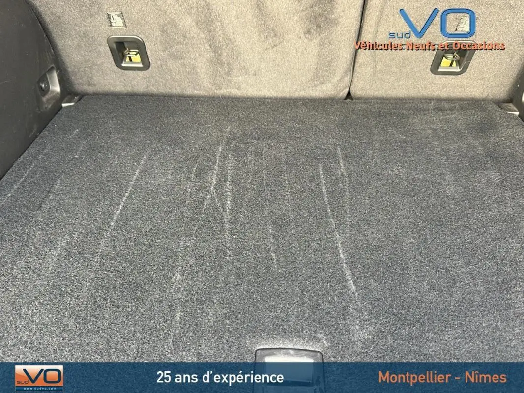 Vue du coffre spacieux et propre du Jeep Compass gris 2024, mettant en valeur la moquette et les fixations arrière.