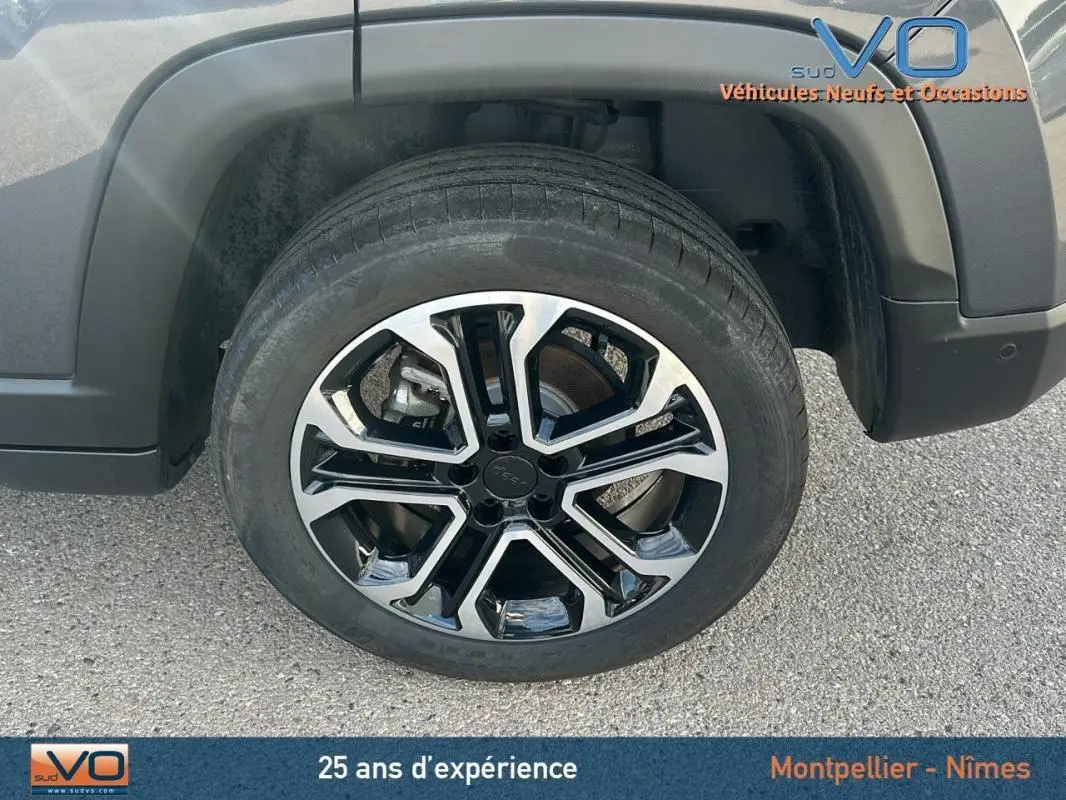 Gros plan sur la roue avant gauche avec jante alliage 18 pouces du Jeep Compass gris 2024 e-Hybrid Altitude.