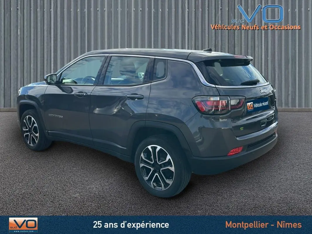 Jeep Compass gris en vue 3/4 arrière droit, avec jantes alliage 18 pouces et feux arrière LED visibles.