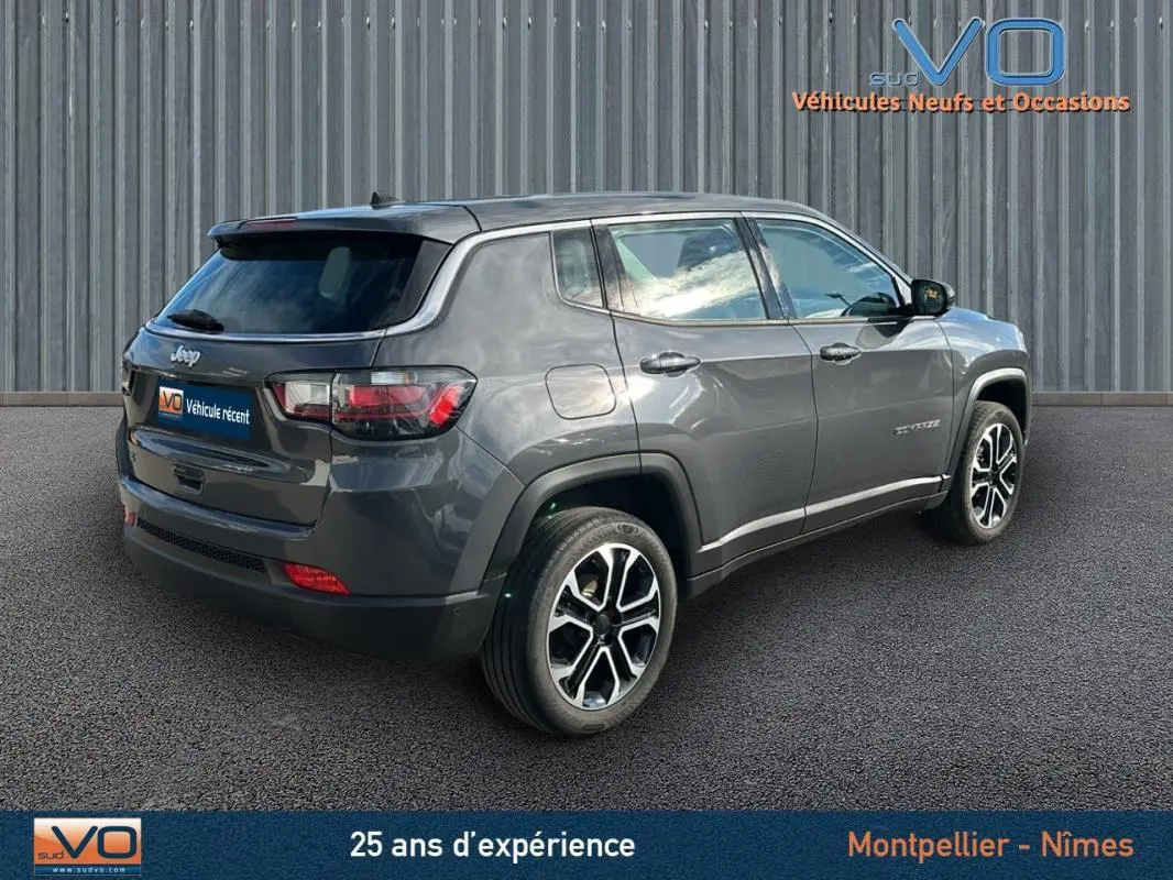 Jeep Compass gris vue 3/4 arrière droit, jantes alliage 18 pouces et feux arrière LED visibles.