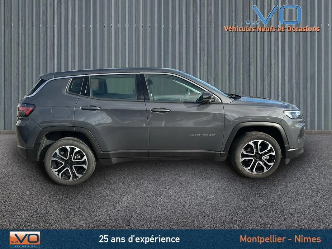 Profil côté gauche d'un Jeep Compass gris 2024 avec jantes alliage 18 pouces sur fond industriel.