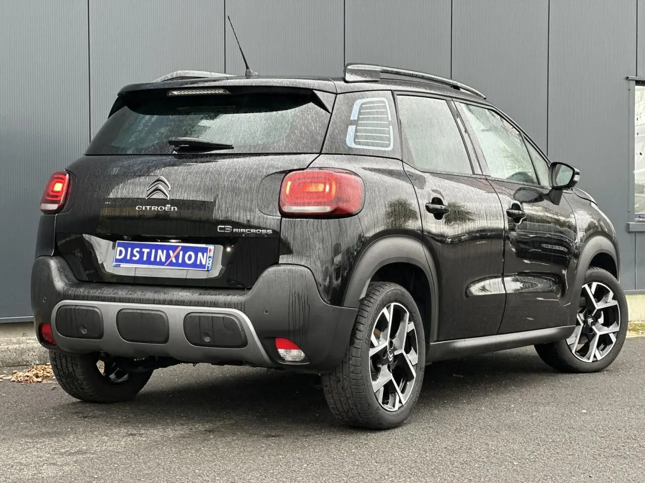 Citroën C3 Aircross noir Perla vue 3/4 arrière droit avec jantes alliage et barres de toit noires brillantes.