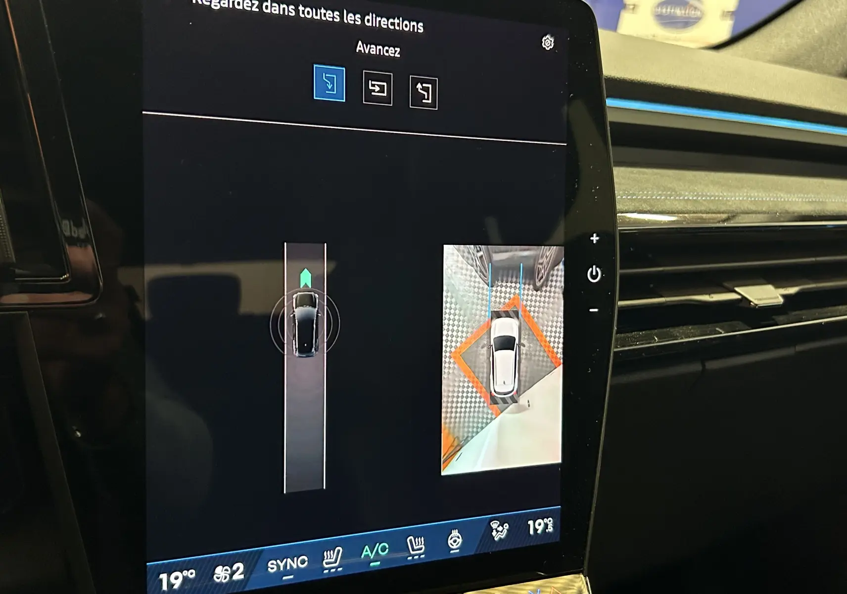Écran tactile intérieur montrant la caméra 360° et l'aide au stationnement du Renault Austral blanc nacré satin.