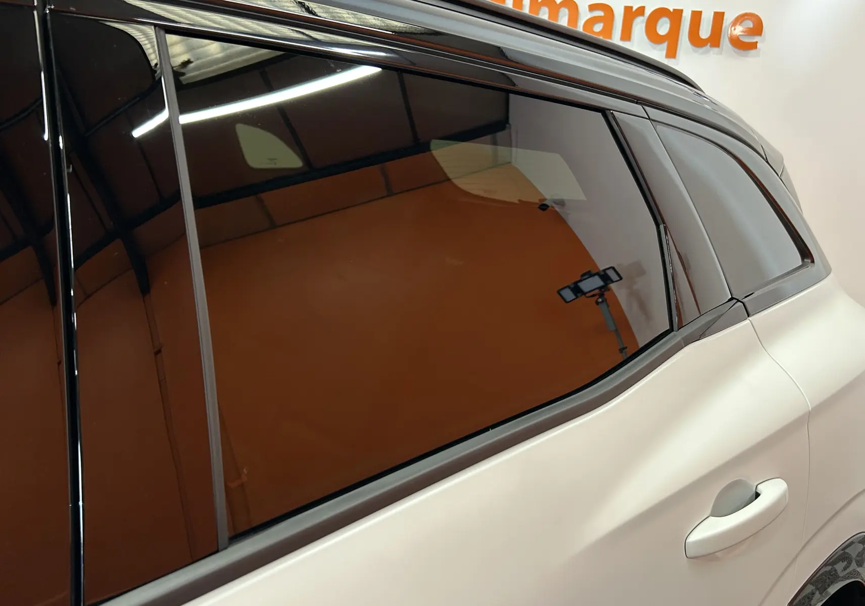 Vue rapprochée du côté arrière droit du Renault Austral blanc nacré satin, mettant en valeur la vitre teintée et la poignée de porte.