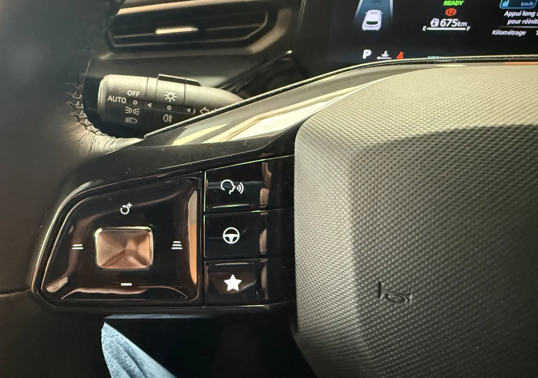 Gros plan sur les commandes au volant à gauche du MG3 1.5 L Hybrid+ 2025, avec tableau de bord numérique en arrière-plan.