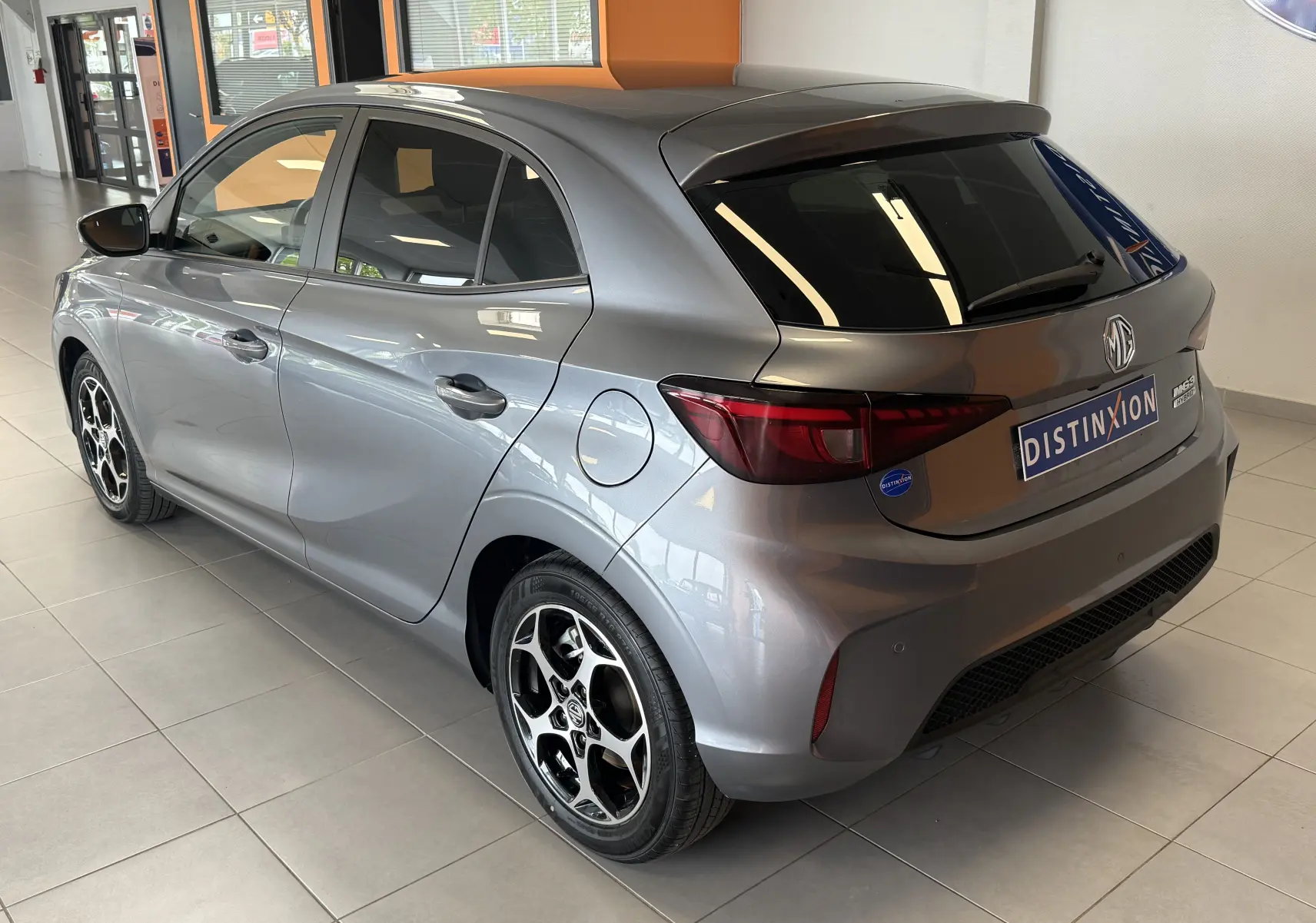 Vue 3/4 arrière droite de la MG3 1.5L Hybrid+ 195 ch Luxury en gris hampstead avec jantes alliage 16 pouces à 5 branches en Y.