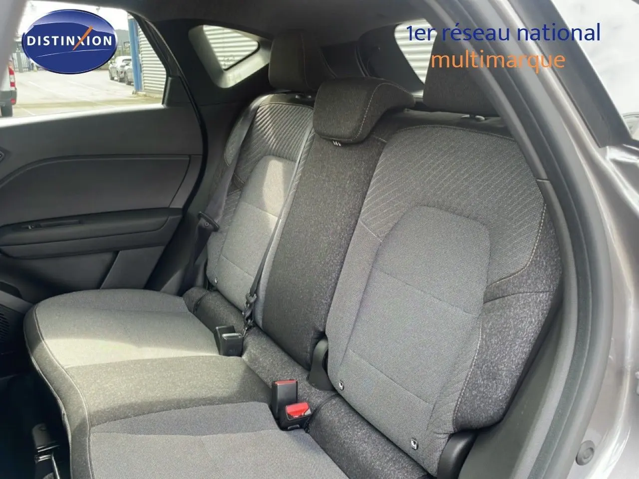 Vue intérieure côté droit montrant la banquette arrière grise du Renault Captur 2025 avec tissu bi-ton et appuie-têtes intégrés.