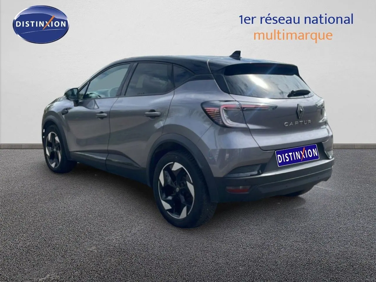 Vue 3/4 arrière droite d'un Renault Captur gris Cassiopée métal avec toit noir, jantes bi-ton et feux LED distinctifs.