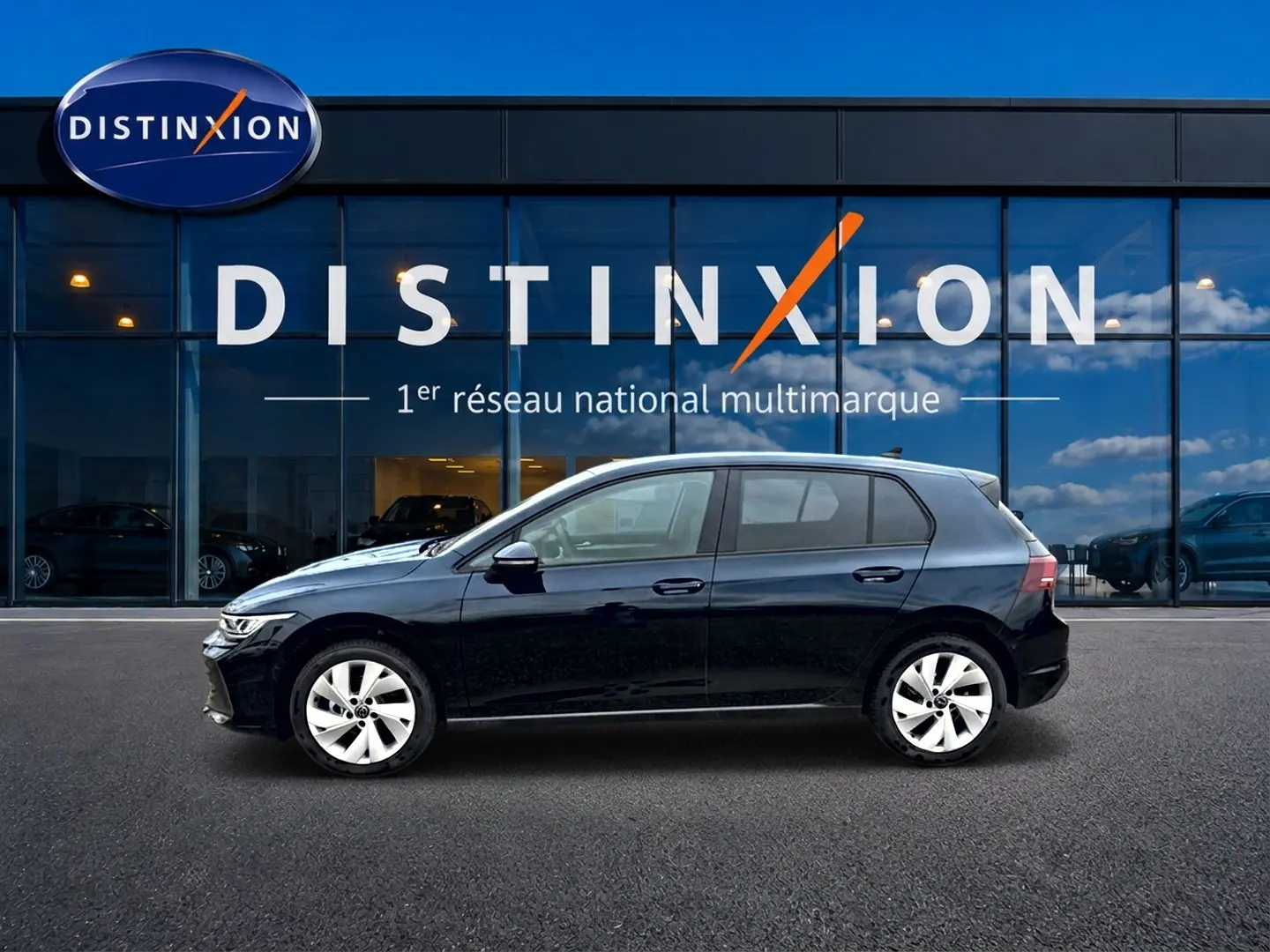 Vue de profil côté gauche d'une Volkswagen Golf noire 2026 garée devant une vitrine avec logo Distinxion.