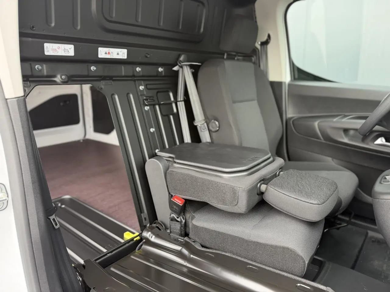 Vue intérieure côté passager du Citroën Berlingo Van XL blanc, avec siège rabattable et plancher bois antidérapant.