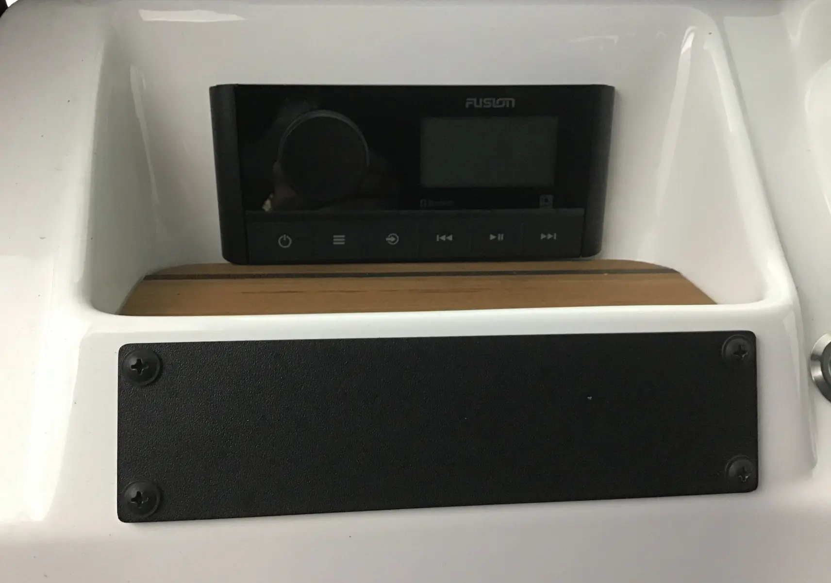 Gros plan sur la radio Fusion noire intégrée au tableau de bord blanc avec plancher teck du MLT E-STORY ICONE 2024.