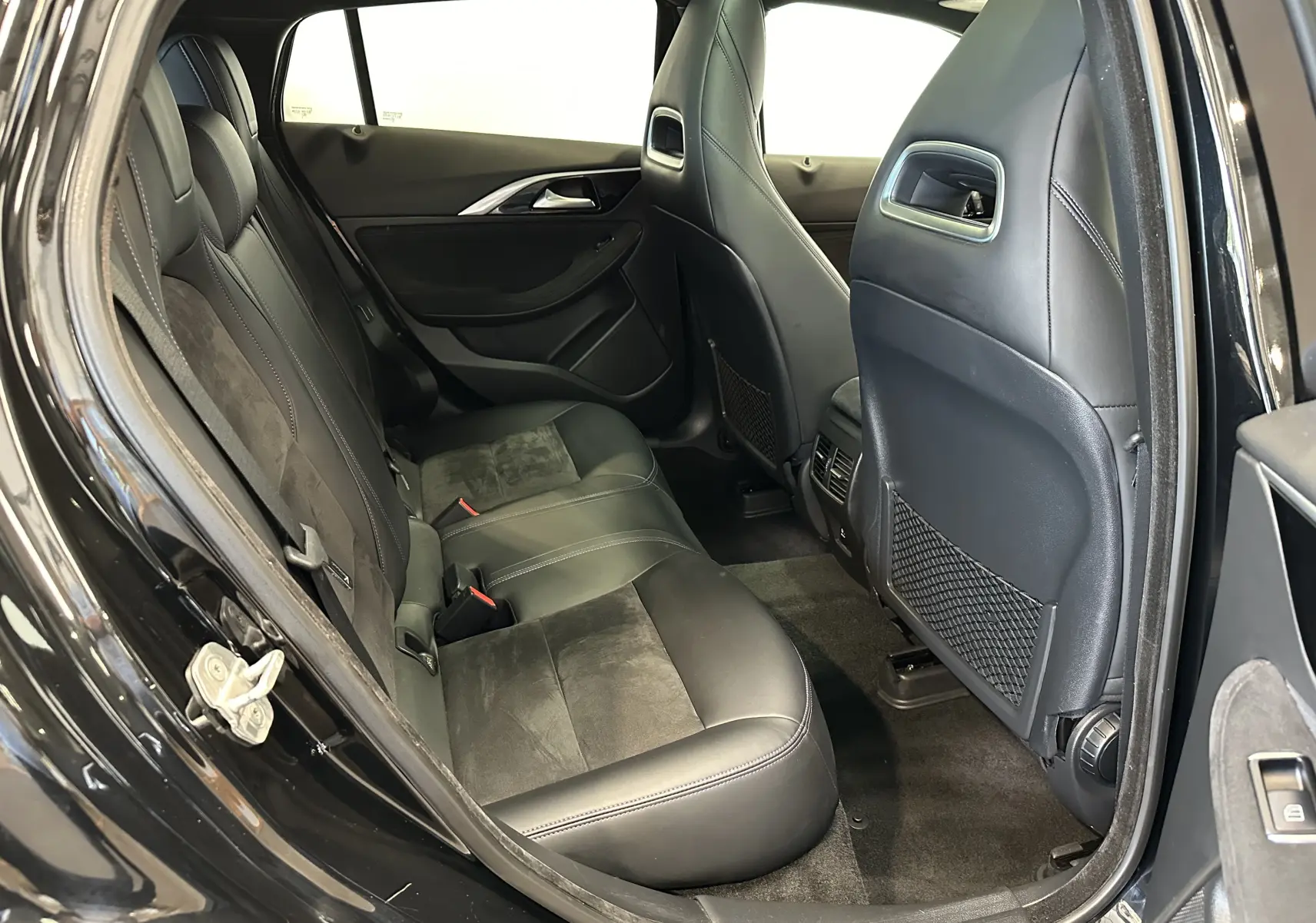 Vue intérieure côté gauche des sièges arrière en cuir noir de l'INFINITI Q30 2016, finition Sport City Black.