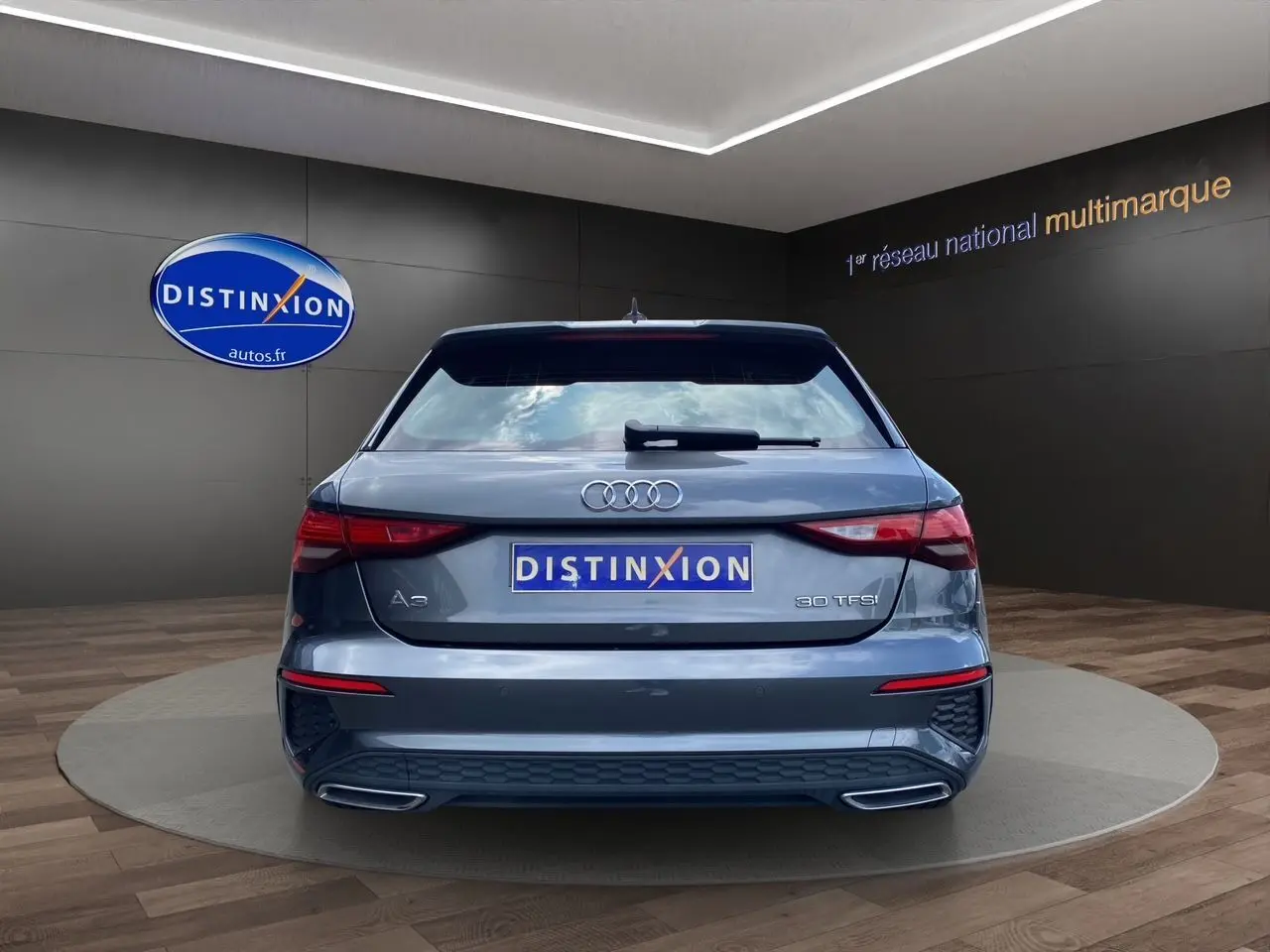 Vue arrière d'une Audi A3 Sportback 30 TFSI gris Daytona avec feux LED et double sortie d'échappement intégrée.