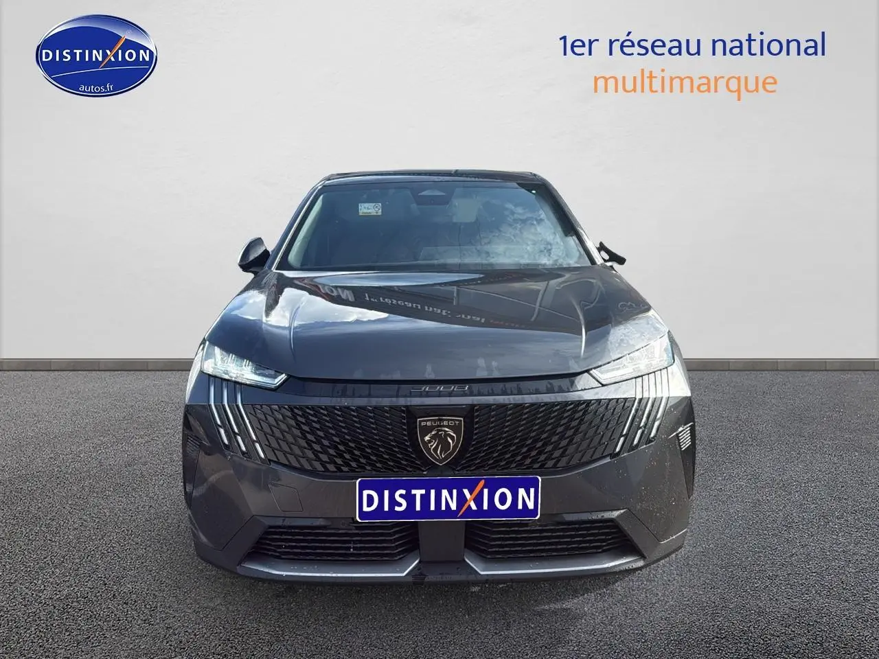 Vue frontale d'un Peugeot 3008 gris titane avec calandre noire et phares LED allumés.