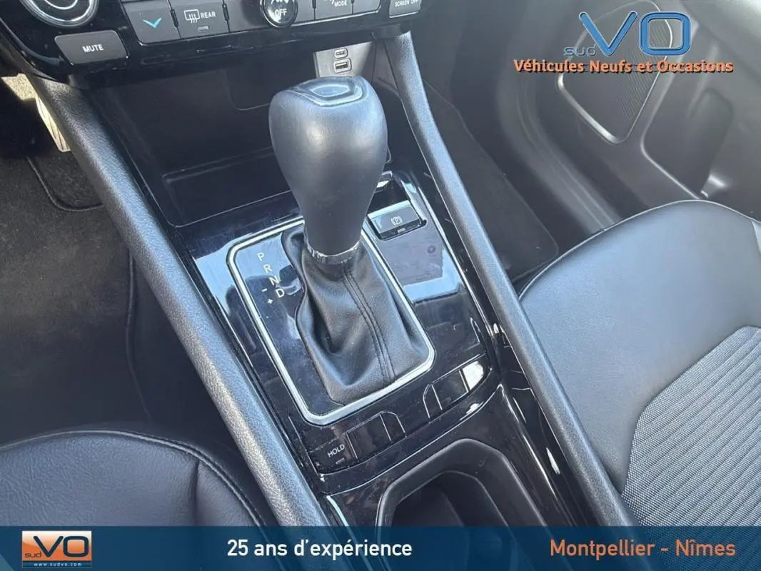 Gros plan sur la console centrale et levier de vitesse automatique du Jeep Compass blanc 2024 avec accoudoir central.