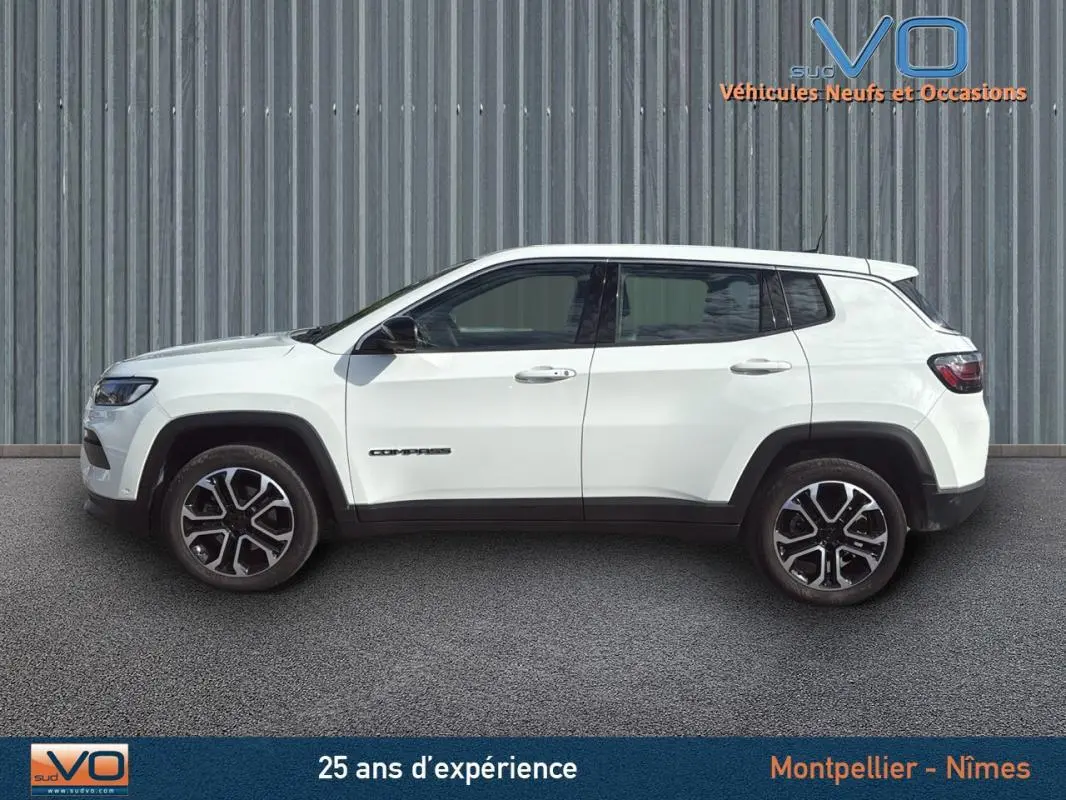 Profil latéral droit du Jeep Compass blanc 2024 avec jantes alliage 18 pouces et logo visible sur la porte