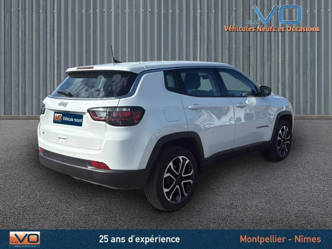 Jeep Compass blanc en vue 3/4 arrière droit, avec jantes alliage 18 pouces et vitres teintées.