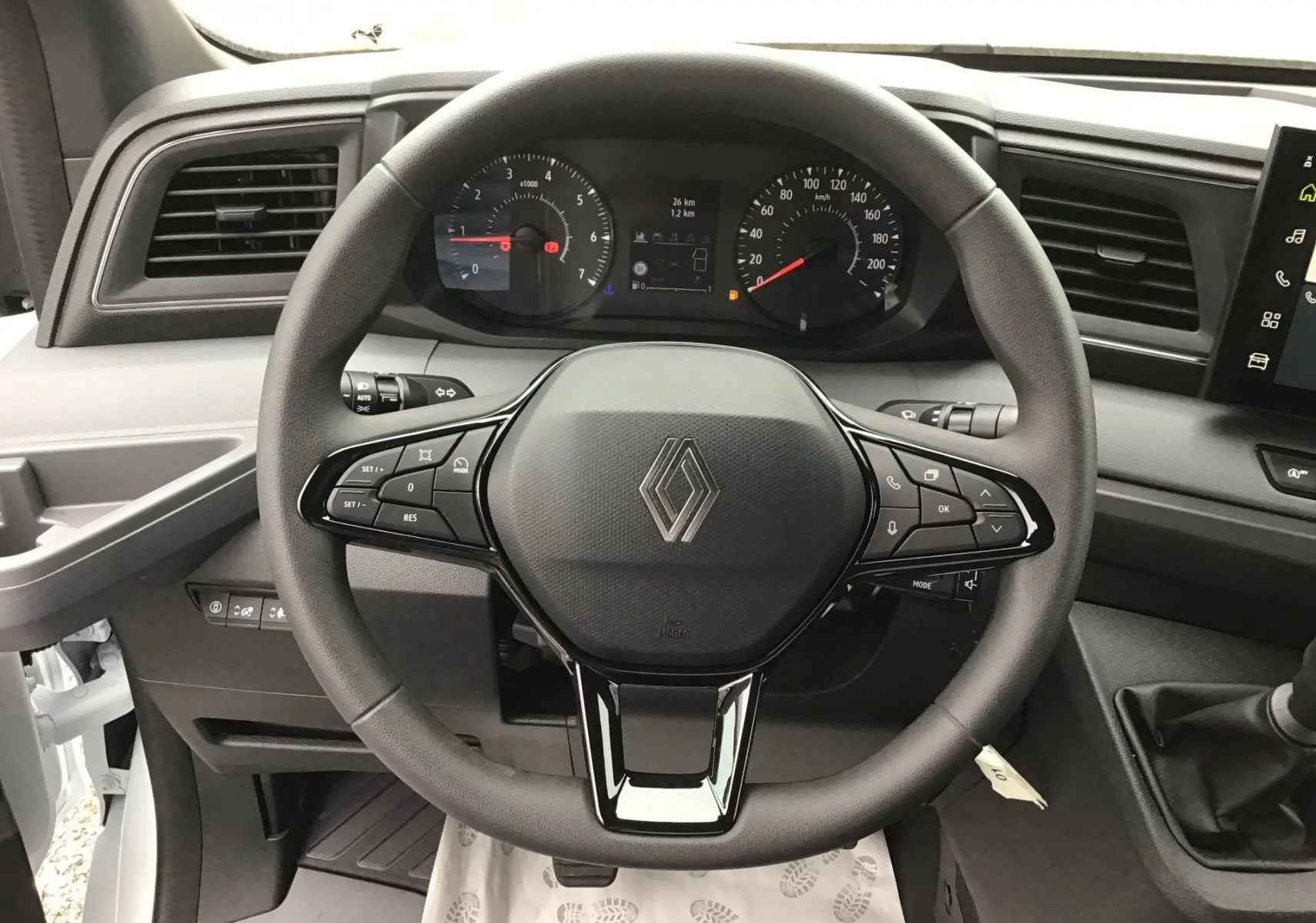 Vue rapprochée du volant noir du Renault Master 2025 avec tableau de bord et commandes intégrées visibles.