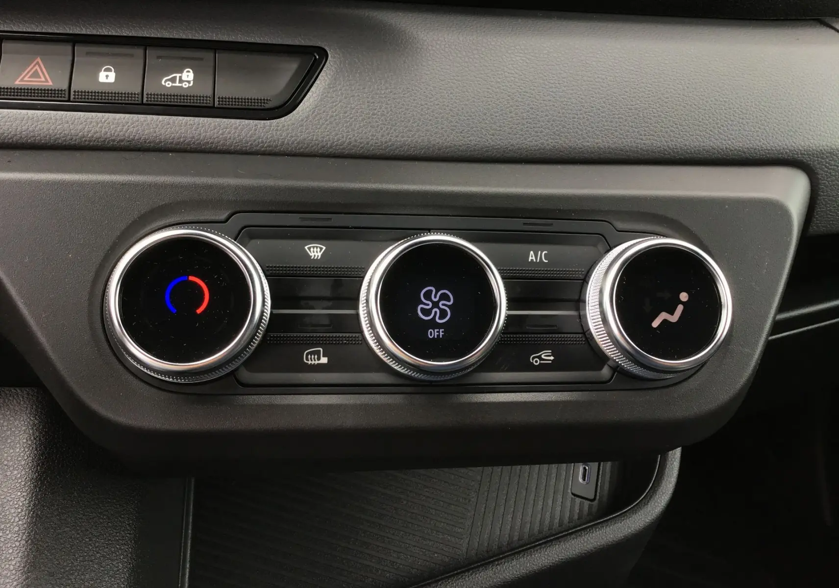 Gros plan sur les commandes de climatisation du tableau de bord du Renault Master blanc 2025, avec réglages circulaires lumineux.