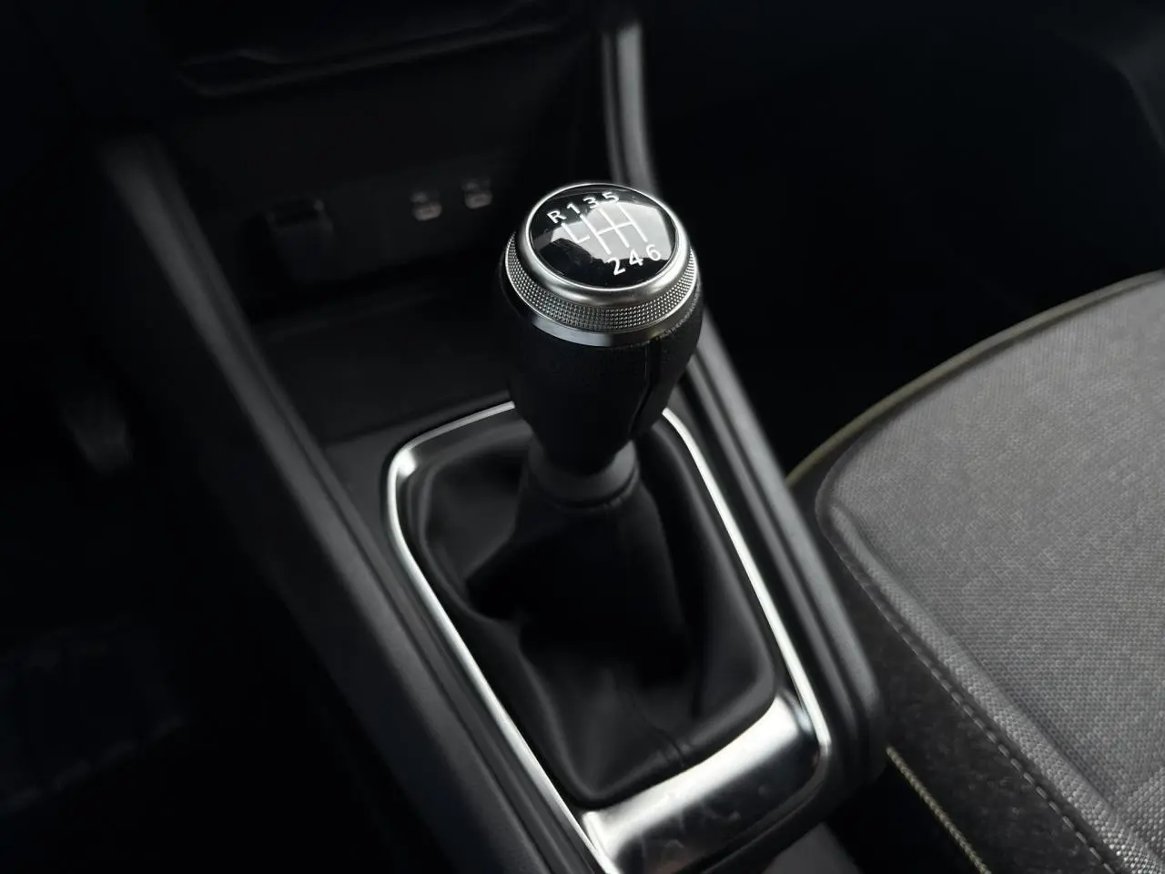Gros plan sur le levier de vitesses manuel noir du Renault Captur 2025, avec siège gris partiellement visible.