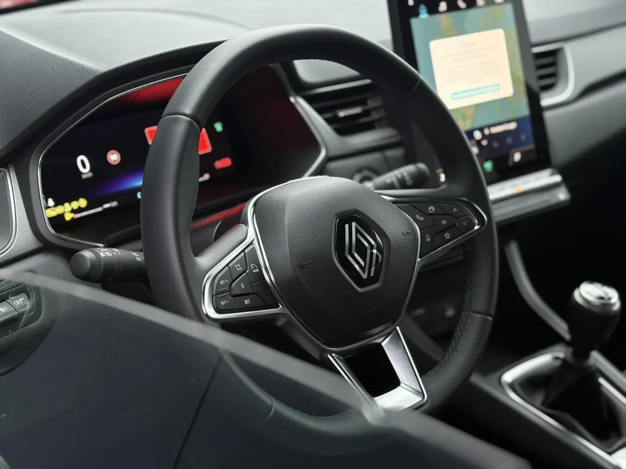 Vue intérieure centrée sur le volant noir du Renault Captur 2025 avec tableau de bord numérique et écran tactile vertical.