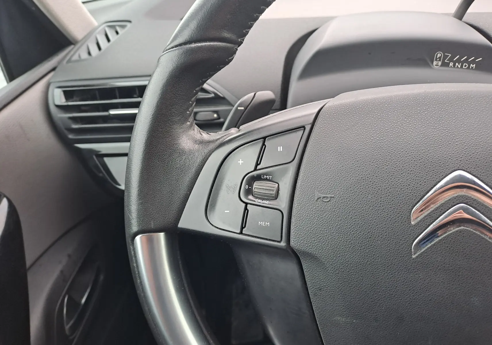 Gros plan sur le volant noir de la Citroën C4 Spacetourer blanc, avec commandes de régulateur de vitesse visibles.