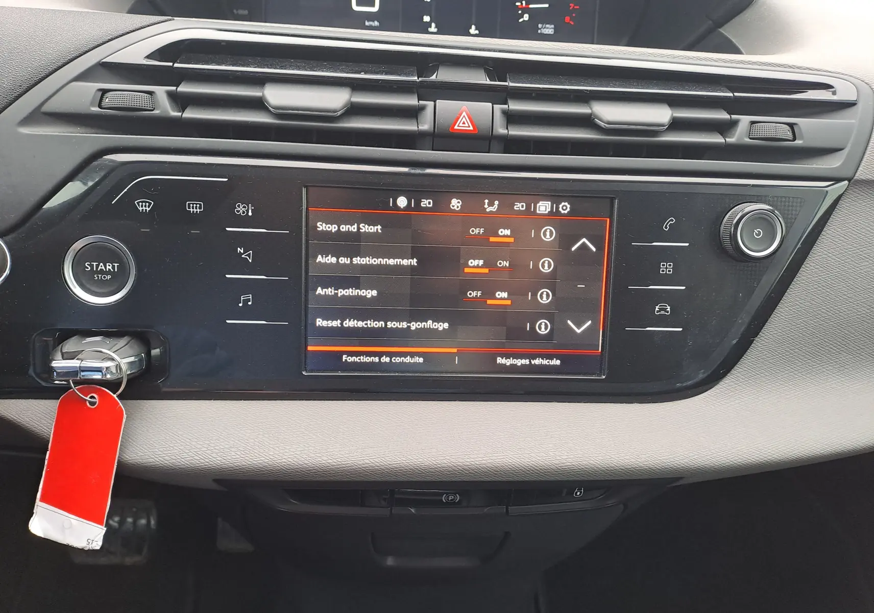 Vue rapprochée de la console centrale noire du Citroën C4 Spacetourer avec écran tactile et bouton Start/Stop visible.
