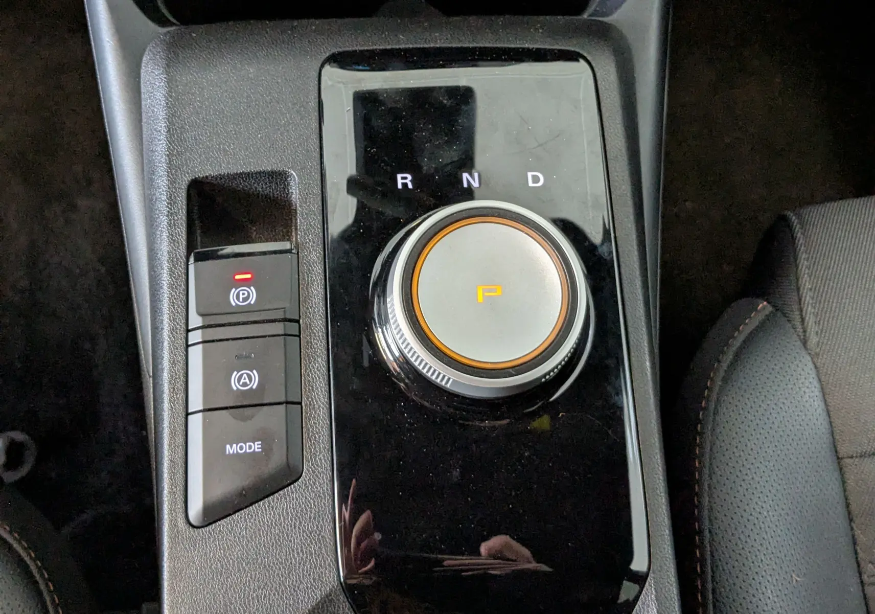 Gros plan sur la molette de sélection de la boîte auto et les boutons de contrôle sur la console centrale noire du MG3 1.5 L Hybrid+ cosmic silver.