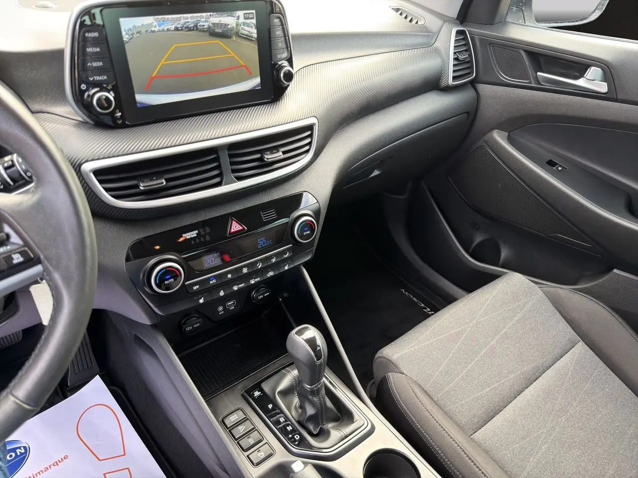 Vue intérieure côté passager du tableau de bord et console centrale du Hyundai Tucson 2020 avec écran tactile et boîte automatique.