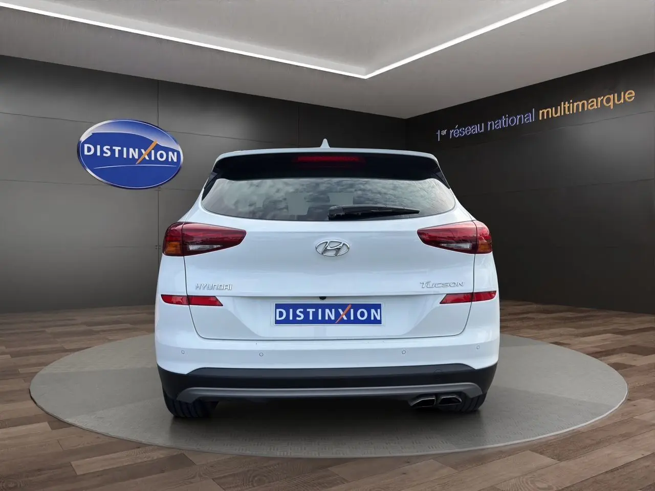 Vue arrière d'un Hyundai Tucson blanc polar 2020 avec feux arrière allongés et double sortie d'échappement.