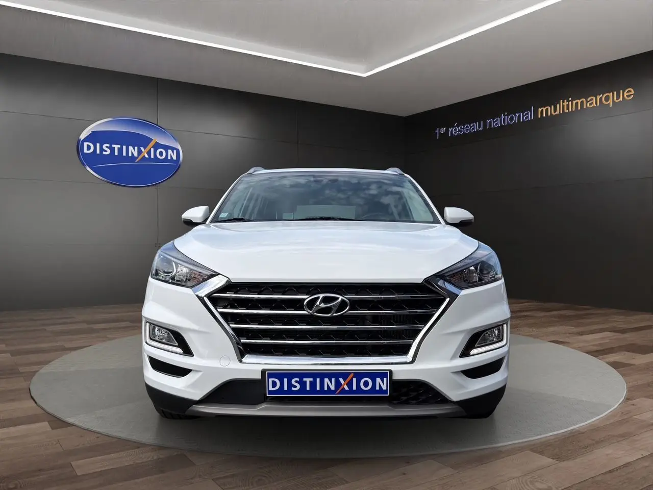 Vue frontale d'un Hyundai Tucson blanc polar 2020 avec calandre noire et logo Hyundai bien visible.